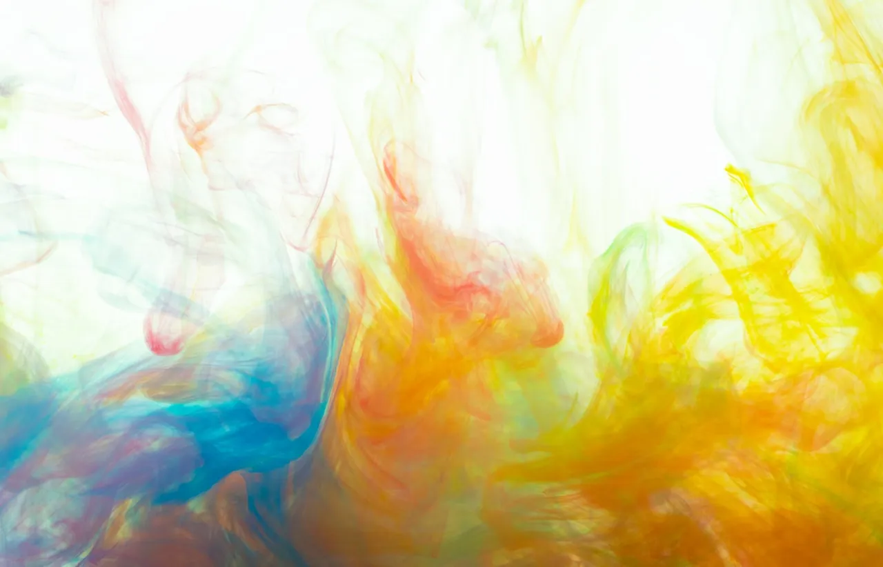 Layers of coloured ink bleeding into one another in a dense abstract wash